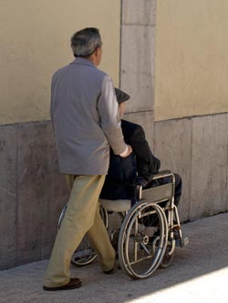hombre paseando a otro en silla de ruedas